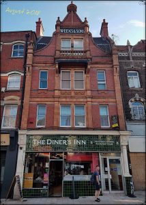 Green tile frontage of Civic Pride era, mid-3-storey-terrace, shop front