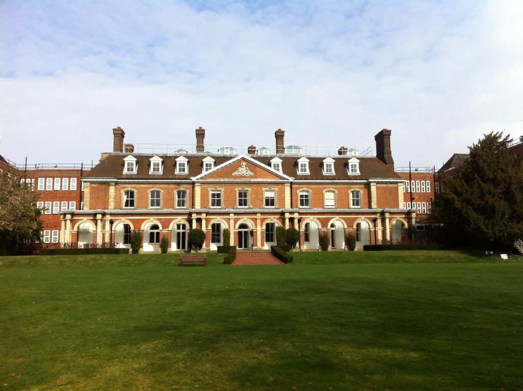 View of lawn and stately home with tall chimneys