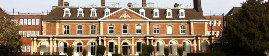 View of lawn and stately home with tall chimneys