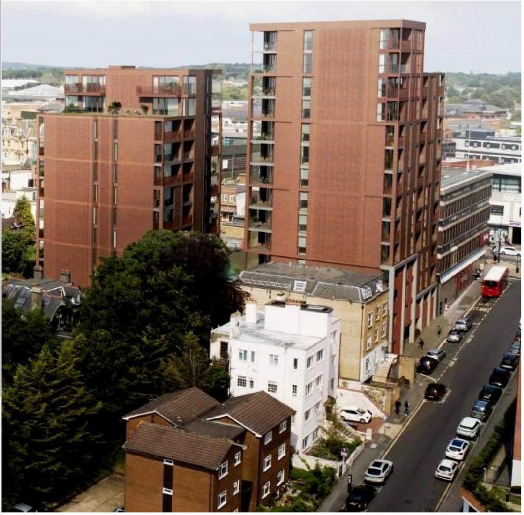 Two huge tower blocks viewed from high above a residential road